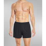 Man lounging in SilkCut boxers in minimal bedroom scene